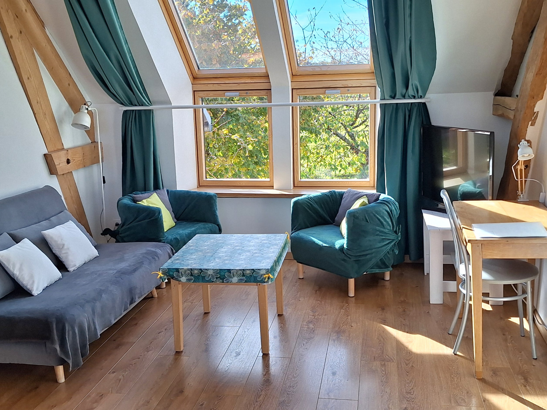 Gîte Le Petit Verger - Pièce de vie lumineuse avec canapé et fauteuils sous les combles